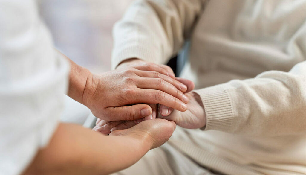 Nurse holing hands with senior patient